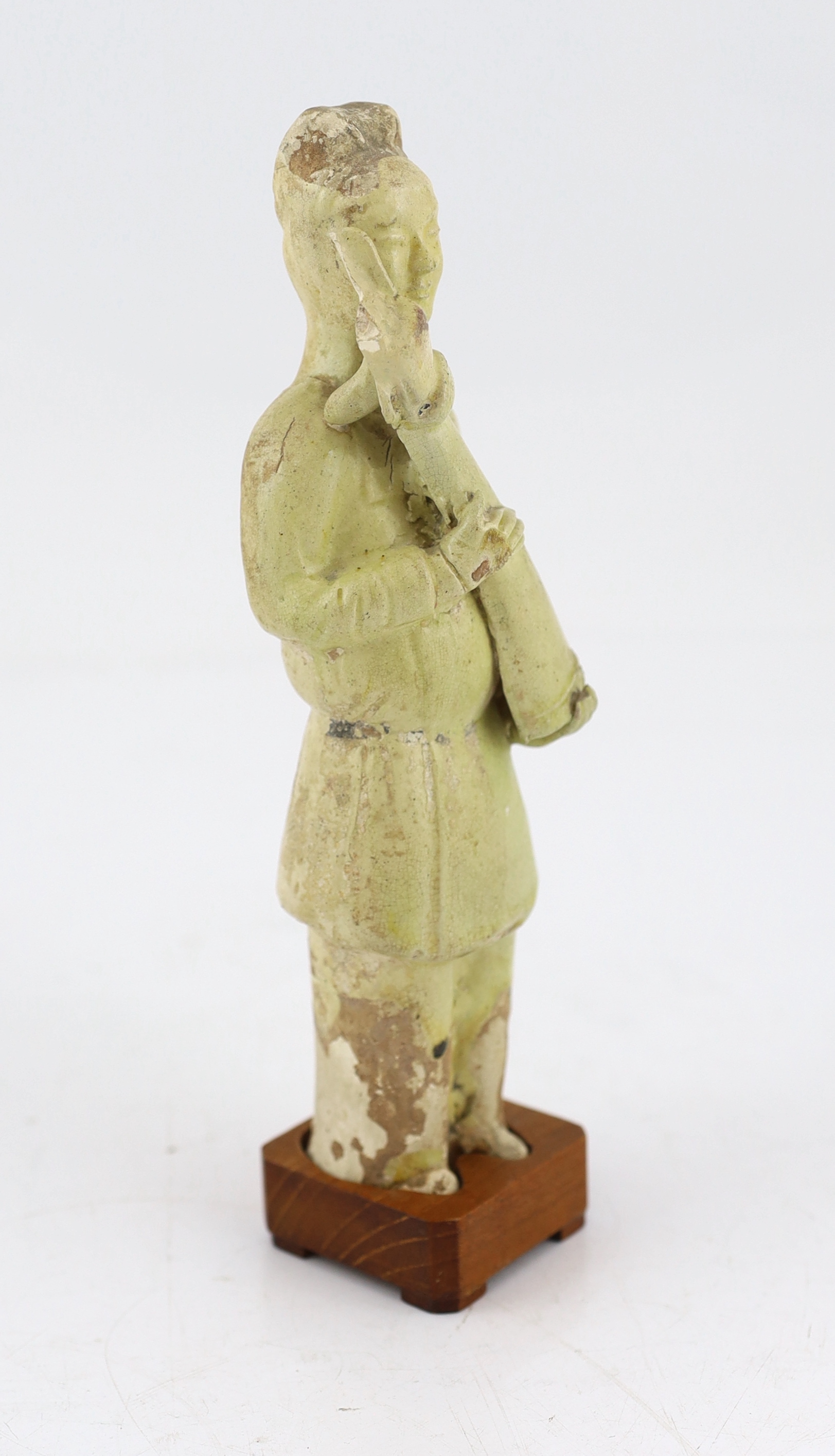 A Chinese pale green glazed pottery figure of an attendant, Tang dynasty (618-906 AD)